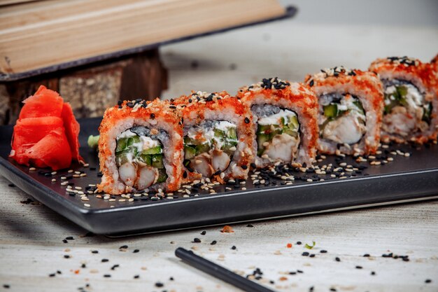 Close up di involtini di sushi con gamberi, cetrioli, ricoperti di tobiko rosso