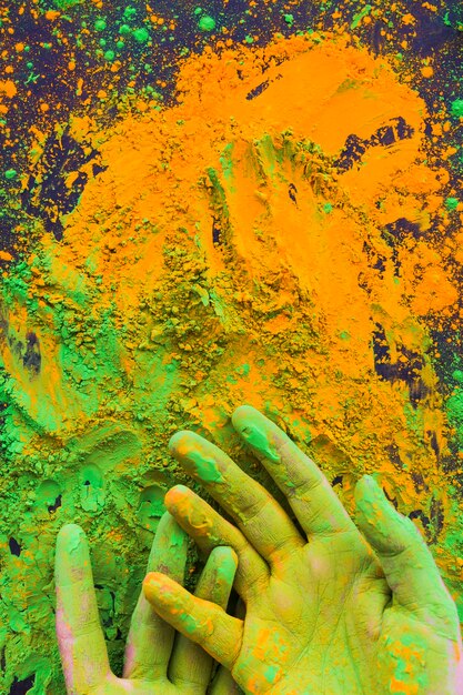 Close-up di mano dipinta con polvere di colore holi