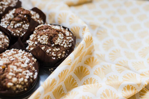Close-up di muffin al cioccolato in carta marrone sopra la tovaglia