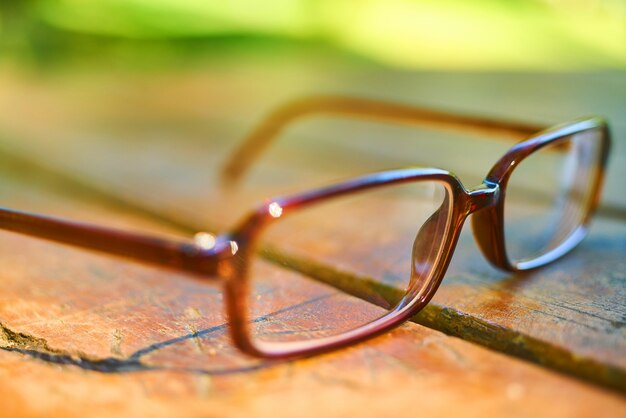 Close-up di occhiali marroni sul pavimento di legno