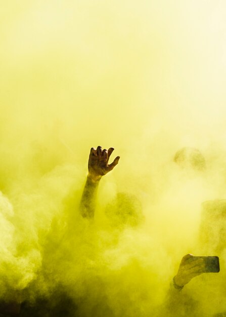 Close-up di persone che ballano e in giallo esplosione di colori holi