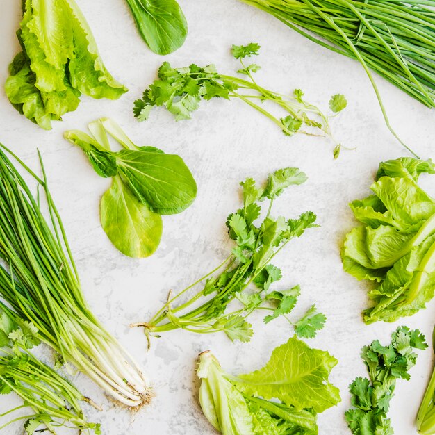 Close-up di verdure fresche verdi su superficie bianca
