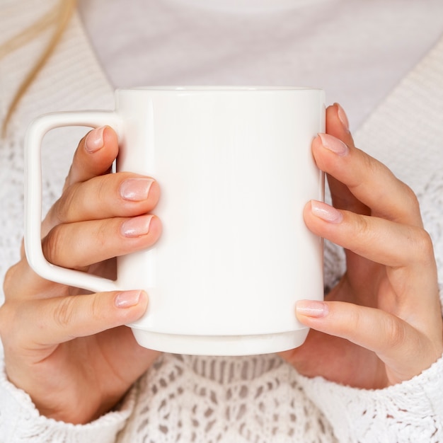 Close-up donna con maglione e tazza