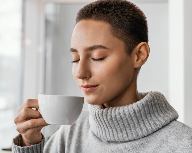 Close-up donna sentente l'odore del caffè