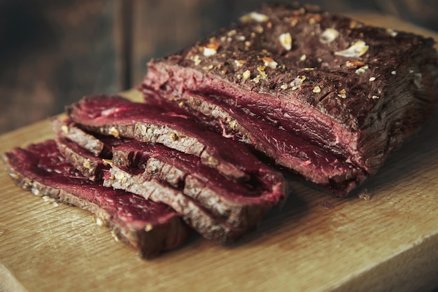 Close up focus carne alla griglia a fette sottili su tavola di legno