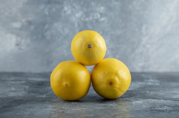 Close up foto di freschi limoni gialli su sfondo grigio.