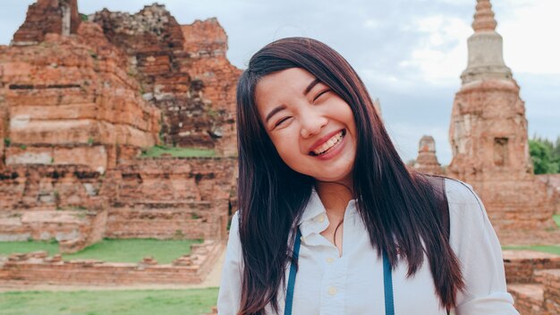 Close-up giovane asiatico backpacker blogger donna alla pagoda vecchia città