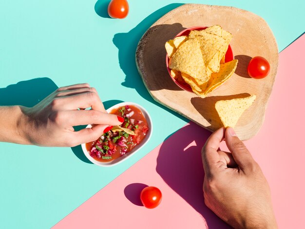 Close-up persone con salsa e tortilla chips