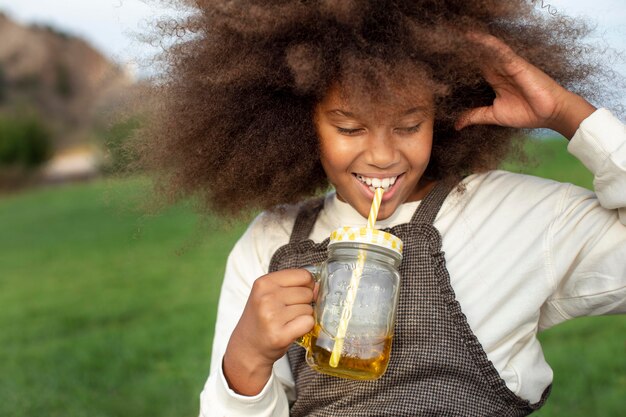 Close up ragazza sorridente che tiene il succo