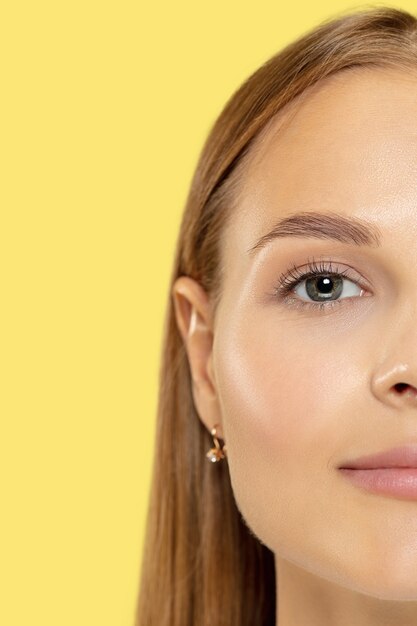 Close up shot della giovane donna caucasica su studio giallo