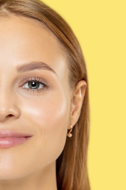 Close up shot della giovane donna caucasica su studio giallo