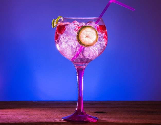 Closeup colpo di gin tonic rosa con lamponi e lime