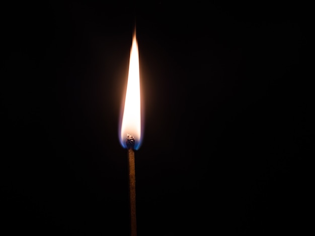 Closeup colpo di un fiammifero acceso bastone con uno sfondo nero