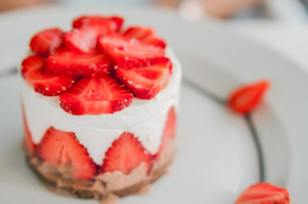 Closeup della torta di fragole con fragola fresca su sfondo di legno. Torta di fragole fatta in casa. Torta di formaggio con fragola