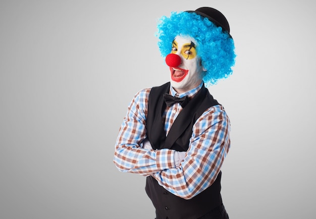 Clown con le braccia incrociate che si affaccia divertente