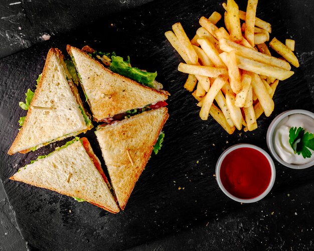 Club sandwich con ketchup di pomodoro, maionese e patate.