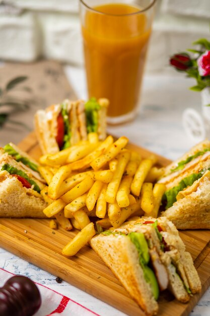 Club sandwich servito con patatine fritte e bibita, maionese, ketchup