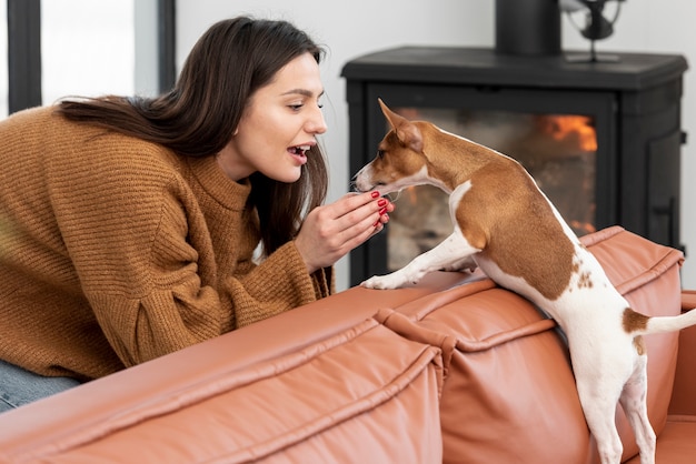 Coccole della donna il suo cane nel salone