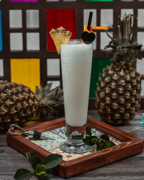 Cocktail al latte di cocco con fetta di ananas sulla parte superiore