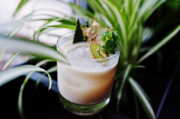 Cocktail alcolico con kiwi in vetro sul tavolo