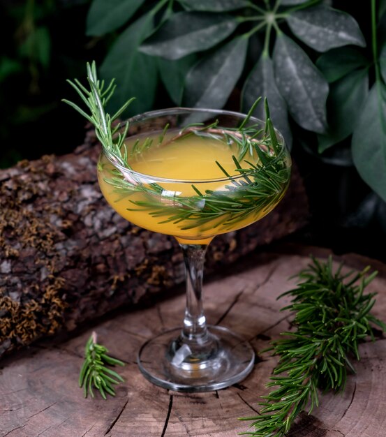 Cocktail arancione con dragoncello sul tavolo