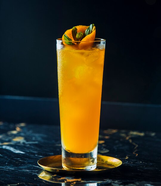 Cocktail arancione con ghiaccio sul tavolo