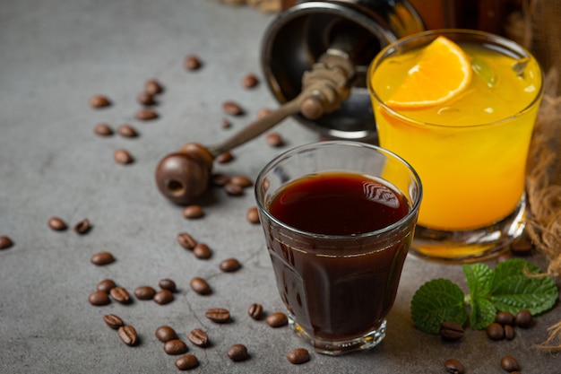 Cocktail di arancia e caffè sulla superficie scura.