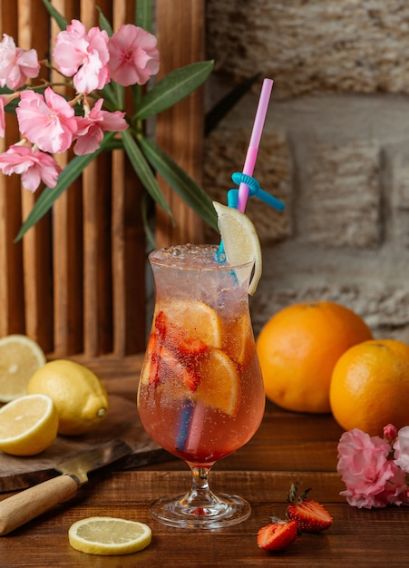 Cocktail di arancia e fragola con fette e ghiaccio di fragola e arancia