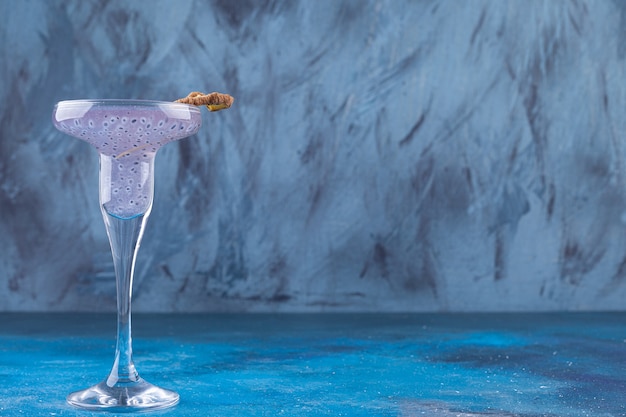 Cocktail di semi di basilico fresco collocato su sfondo blu.