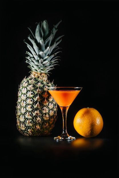 Cocktail e frutta esotica su sfondo nero