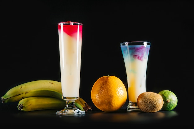 Cocktail e frutta esotica su sfondo nero