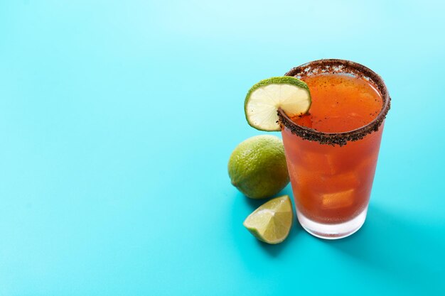 Cocktail michelada fatto in casa con succo di lime alla birra, salsa calda, bordo salato e succo di pomodoro