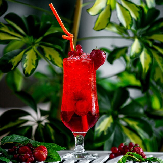 Cocktail rosso della fragola guarnito con la fragola e il mirtillo rosso