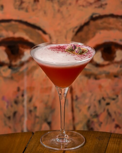 Cocktail rosso spumoso guarnito con boccioli di rosa essiccati