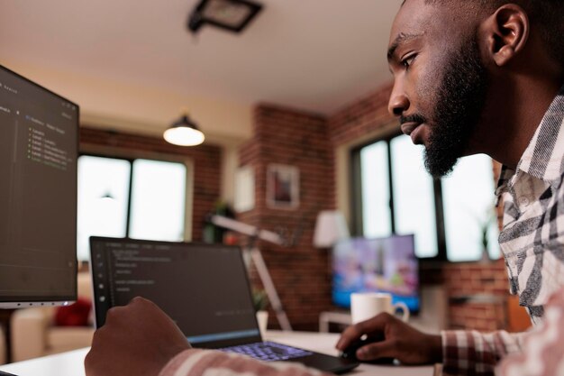 Codificatore afroamericano che programma l'interfaccia di codice binario, utilizzando lo script html CSS e la crittografia sul computer. Server di sicurezza di codifica per libero professionista maschio con applicazione per sviluppatori software.