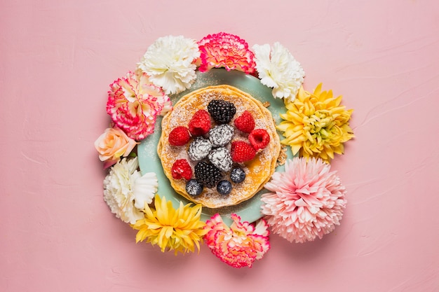 Colazione con fiori e sfondo rosa