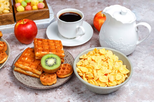 Colazione con vari dolci, wafer, corn flakes e una tazza di caffè, vista dall'alto