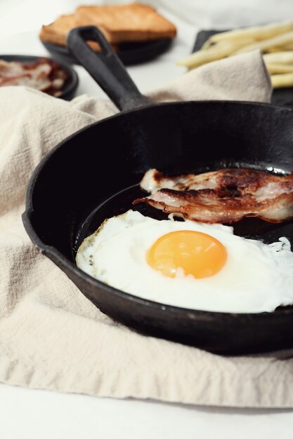 Colazione di uova e pancetta fritta in padella