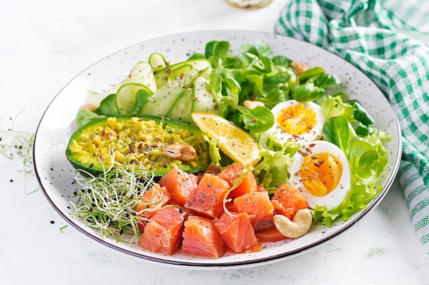 Colazione dietetica chetogenica. Insalata di salmone salato con verdure, cetrioli, uova e avocado. Pranzo Keto / Paleo.