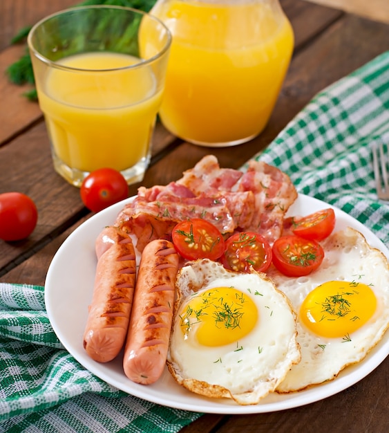 Colazione inglese - toast, uova, pancetta e verdure in stile rustico sul tavolo di legno