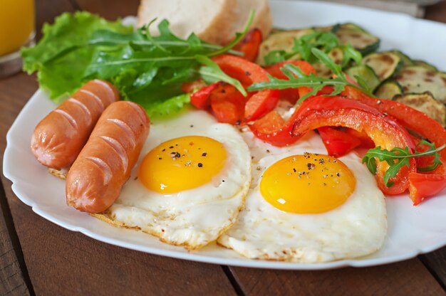 Colazione inglese - uova fritte, salsicce, zucchine e peperoni dolci