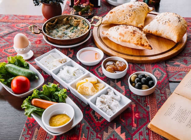 Colazione marmellata miele burro formaggi ricotta salsicce verdure uovo e pane all'aria