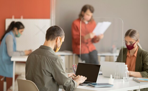 Collaboratori che indossano una maschera facciale al lavoro