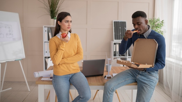 Colleghi al lavoro a mangiare la pizza