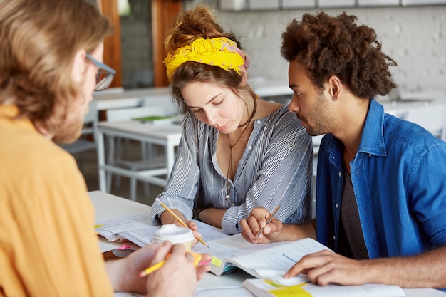 Colleghi che lavorano insieme seduti nella caffetteria