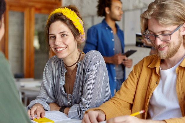 Colleghi che lavorano insieme seduti nella caffetteria