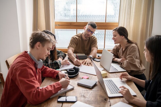 Colleghi che utilizzano laptop e notebook per l'apprendimento in una sessione di studio