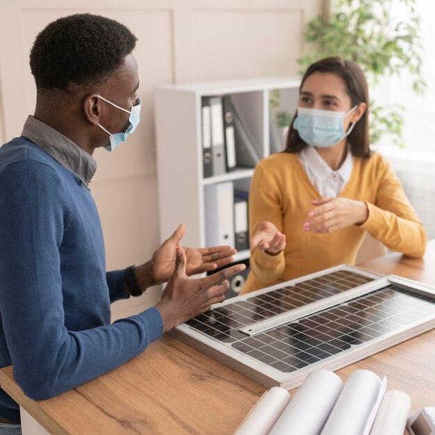 Colleghi con maschere che lavorano insieme al progetto ambientale