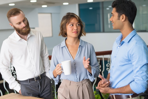 Colleghi di lavoro che discutono lavoro durante la pausa caffè