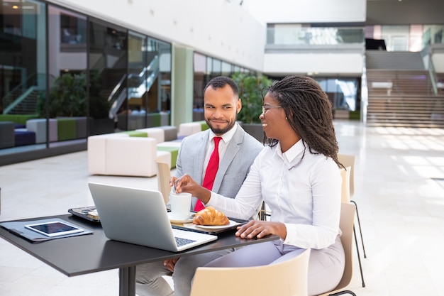 Colleghi di lavoro felice facendo colazione nella caffetteria